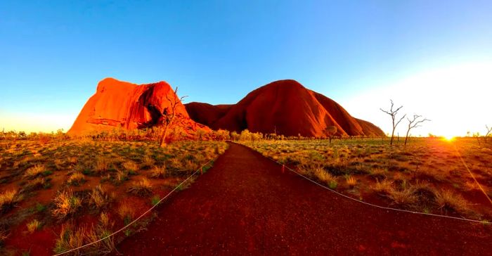 A dirt trail leads to an expansive, flat-topped mountain