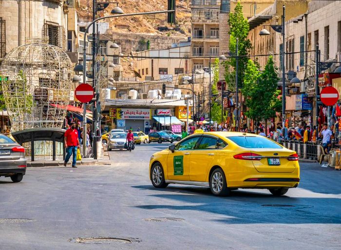 A yellow taxi cruising through a bustling street in Amman, Jordan