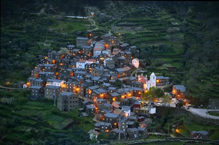 The village of Piódão in Portugal, a charming rural mountain community built on a steep slope, features a collection of traditional stone houses.