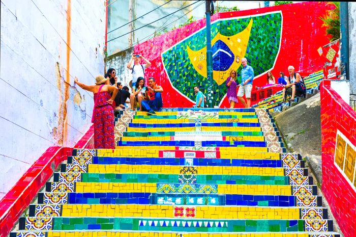 Tourists admiring the vibrant Selaron staircase in Rio de Janeiro, Brazil, created by Chilean artist Jorge Selaron.