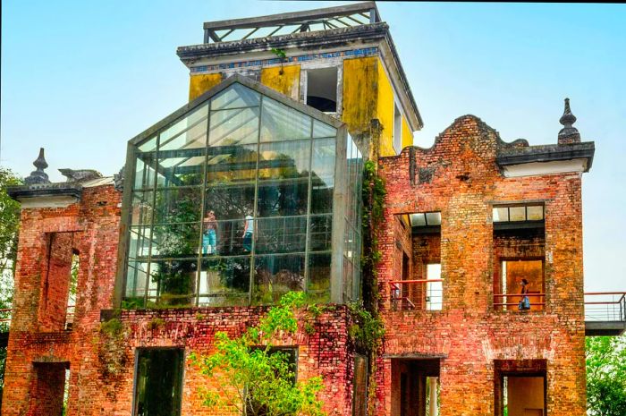 A low-angle perspective shows visitors at a building that looks dilapidated but features a modern glass section.