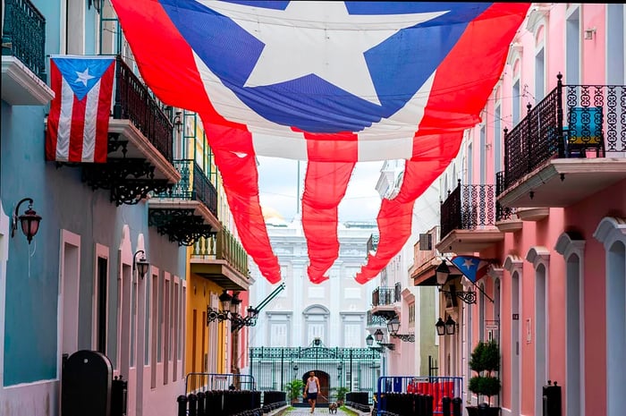 A man strolls beneath the Puerto Rican flag in Old San Juan.