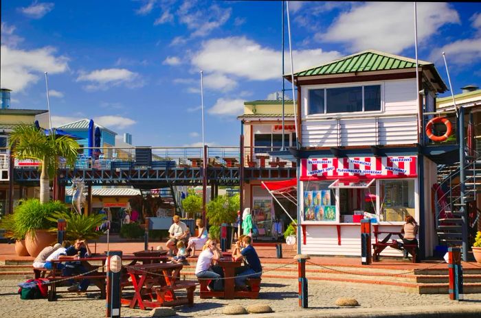 A lively group enjoying food and drinks on the waterfront pier in Knysna