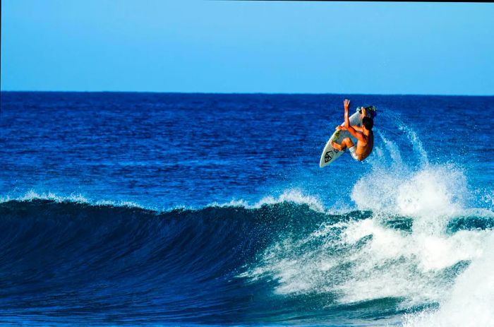 A surfer executing an aerial maneuver near Rincón.