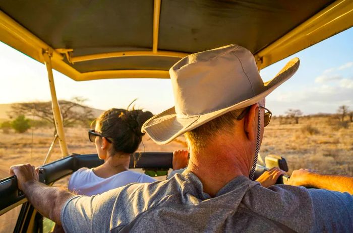 A pair of individuals enjoying the view from a Jeep Safari in Kenya, Africa.