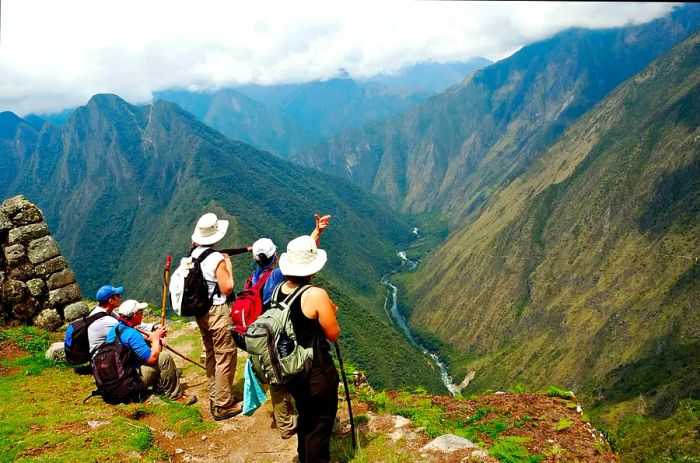 A group of trekkers admire the view over a valley along the Inca Trail in Peru