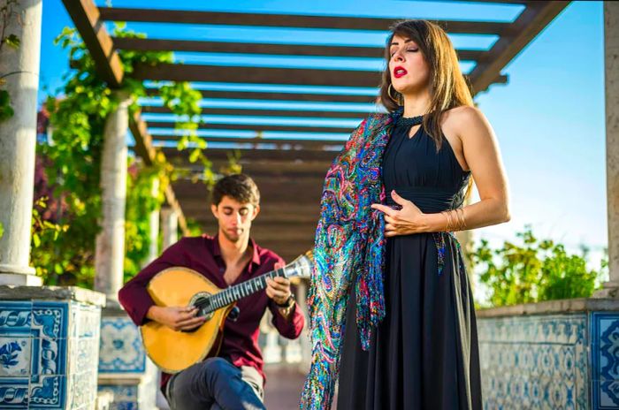 A woman performs a song while a man strums the guitar.