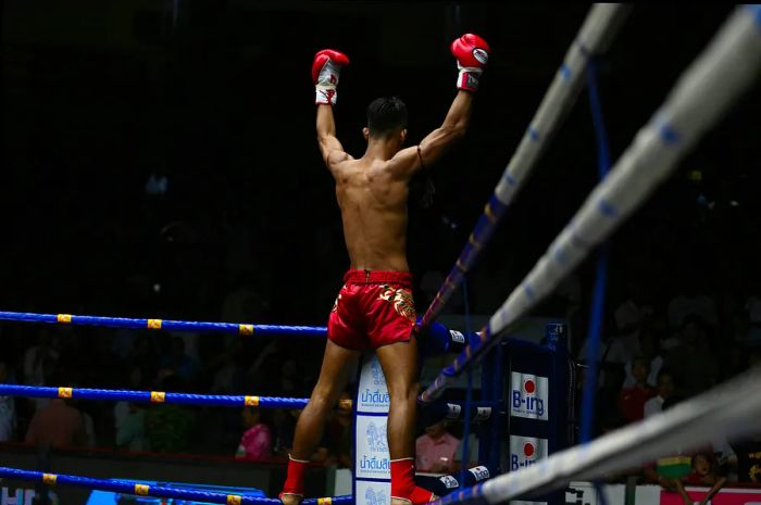 A fighter celebrates his victory after a match at Rajadamnern Stadium in Bangkok.