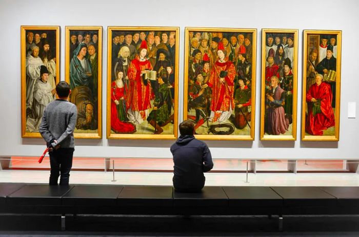 Two men admire a Renaissance artwork at Lisbon's National Museum of Art.