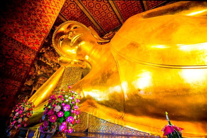 The magnificent golden reclining Buddha statue rests on its side at Wat Pho temple in Bangkok, Thailand.