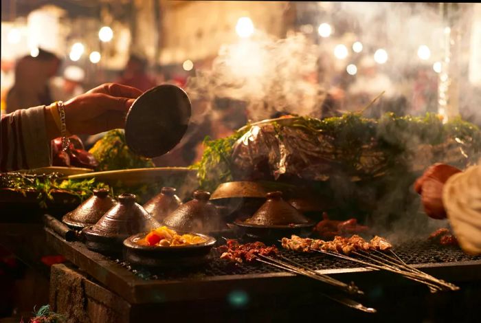 A close-up of a vendor preparing tagine on a grill at a street market in Marrakesh