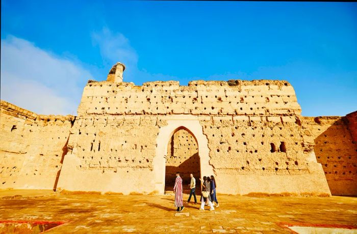 A group strolls past a terra-cotta-hued palace in Marrakesh