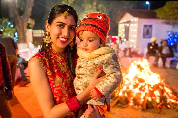 A woman and her son stand by a fire during the Lohri festival in Punjab, India