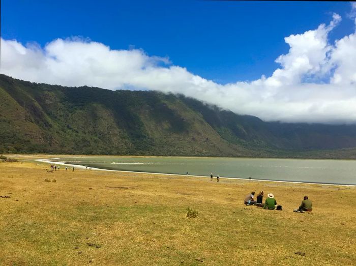 Visitors enjoying the scenic views by the water at the Empakaai Crater, Ngorongoro Conservation Area, Tanzania.