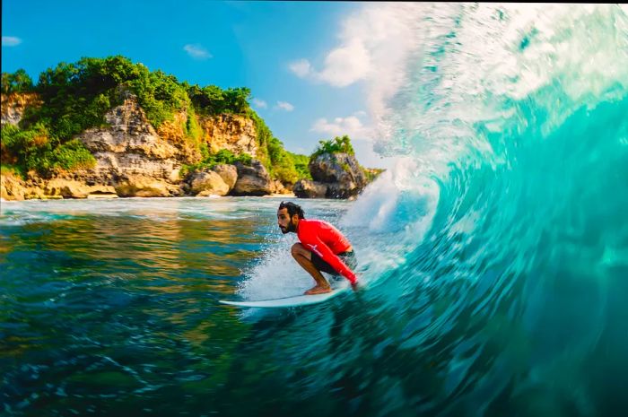 Surfers riding a barrel wave in Bali, Indonesia