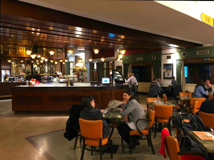 Guests at Kavárna Lucerna seated at round tables, enjoying drinks and conversation