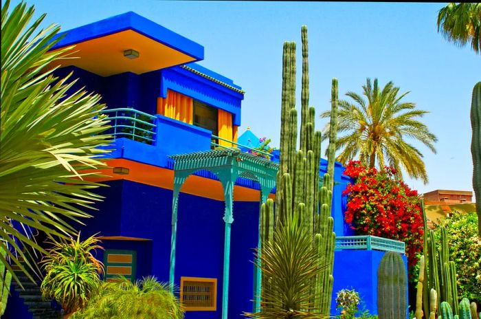 Vibrant blue building accented with yellow in a lush garden