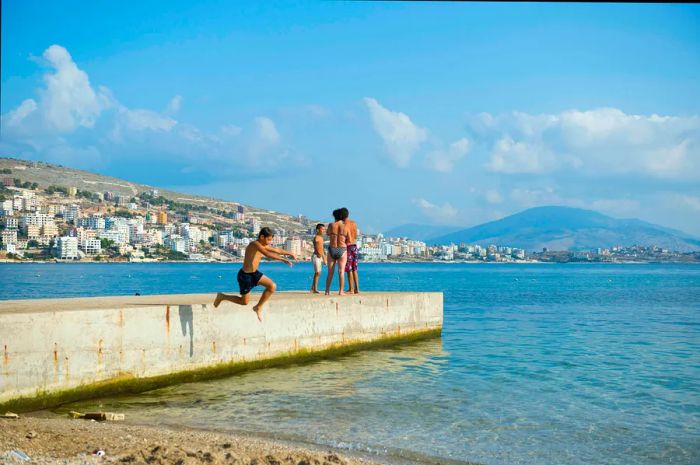 A boy leaps off a pier into the Mediterranean Sea at Saranda, Albania.