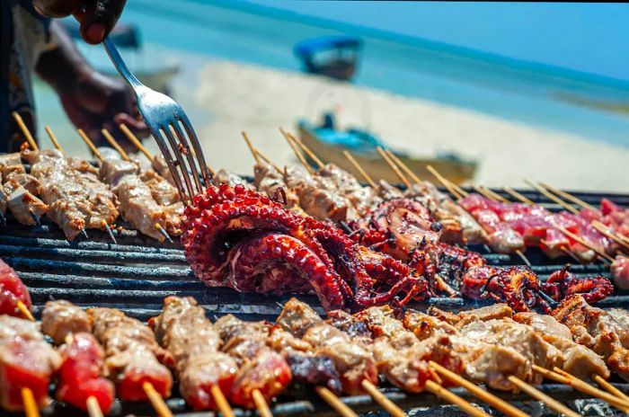 A close-up view of seafood being served at a beach barbecue