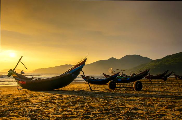 Fishing boats greet the sunrise on the shores of Lang Co, Hue, Vietnam