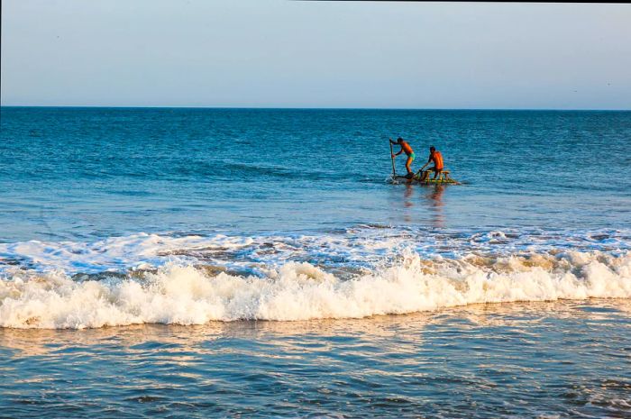 Artisanal fishermen navigate their rafts, returning to shore in Mancora.