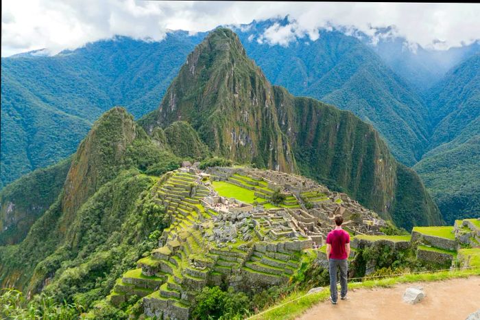 An aerial perspective of a hiker admiring Machu Picchu