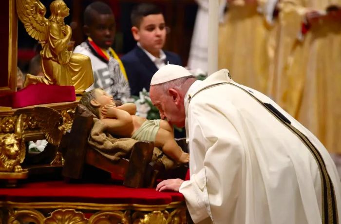 Pope Francis kisses a statue of Jesus during the midnight mass on Christmas Eve at St. Peter's Basilica.