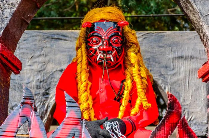 A local performer in Ciudad Vieja, Guatemala, dons a devil mask and costume for a traditional folk dance.