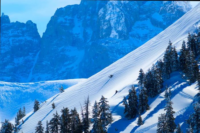 A steep, snow-covered slope framed by rugged mountains at Jackson Hole, Wyoming.