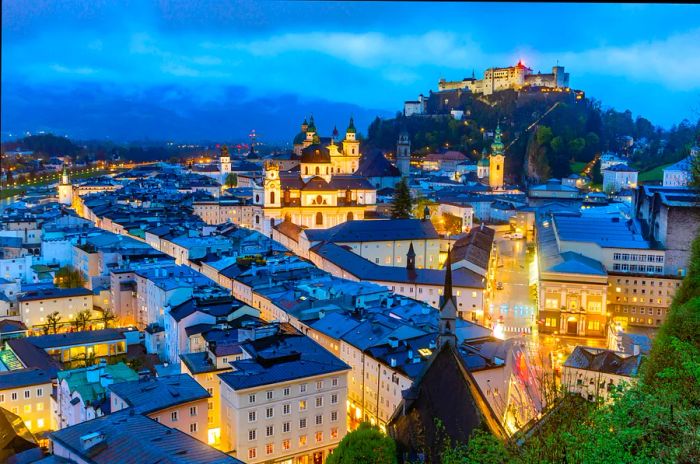 The Salzburg skyline featuring Fortress Hohensalzburg and the Salzach River during the blue hour