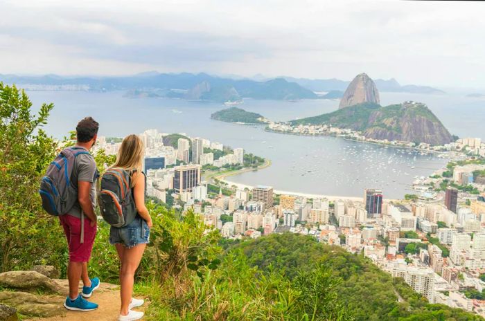 Backpacking travelers enjoying views over a bay framed by mountains