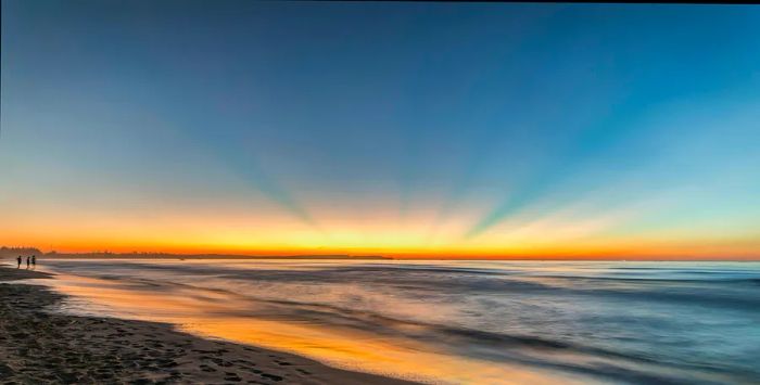 The sun rises over the pristine, golden sands of My Khe Beach, Quang Ngai, Vietnam.