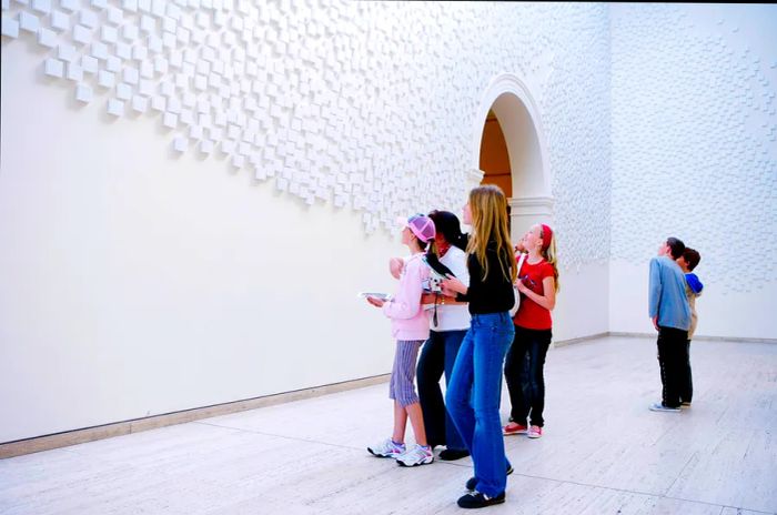 A group of young people admiring artwork in an urban gallery