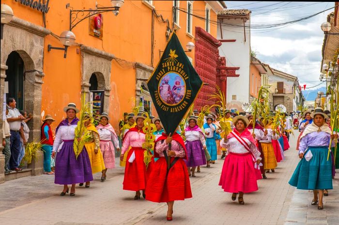 Individuals in vibrant dresses and hats parading during the Palm Sunday celebrations in Ayacucho, Peru.