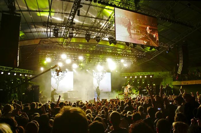 Evermore performing live at the Make Poverty History concert held at the Sidney Myer Music Bowl on November 17, 2006, in Melbourne, Australia, with a large crowd surrounding them.