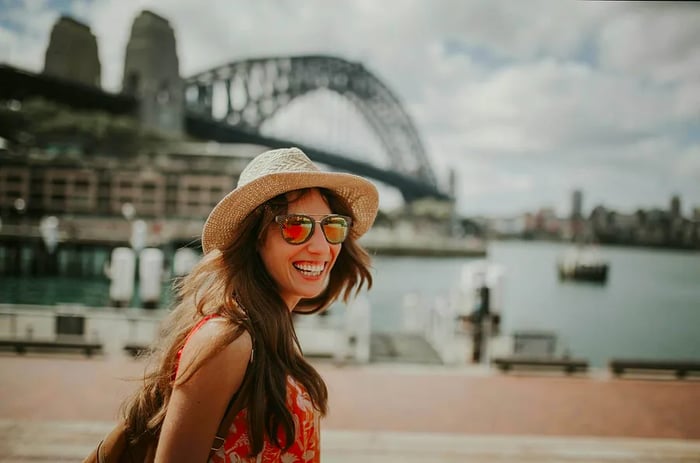 Joyful woman exploring Sydney, with the Harbour Bridge in the backdrop