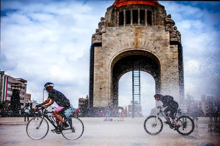 Cyclists pass by the Monumento a la Revolución in Mexico City.