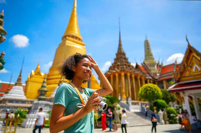 A young woman with a backpack explores the stunning pagoda at Wat Pra Kaew.