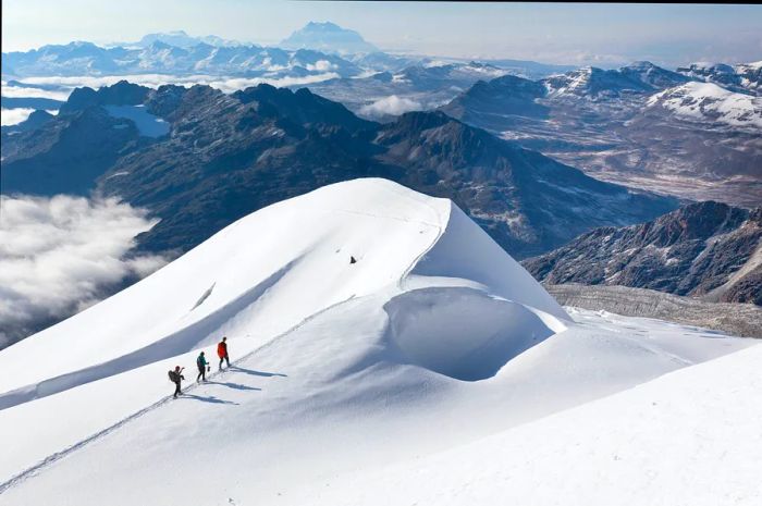 Three climbers on a snowy ridge near Huayna Potosi