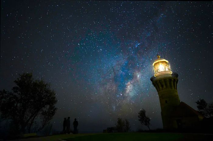 Barrenjoey lighthouse shining under a starlit sky