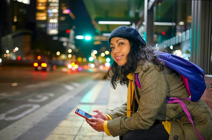 A woman waits at a bus stop in Mexico City during the night for her bus.