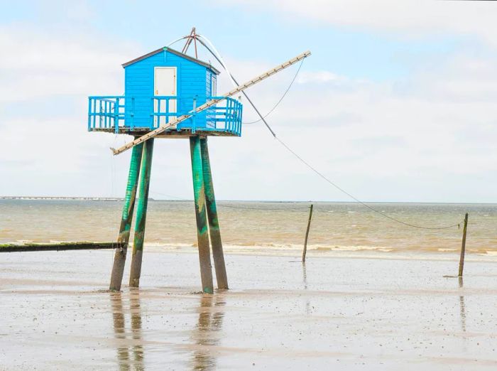 A blue wooden fishing hut contrasts beautifully against the sea at Pornic.