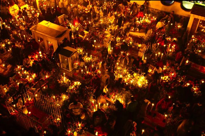 Bathed in candlelight, crowds gather to commemorate the Day of the Dead at the Church of San Andres Apostol cemetery in Mexico.