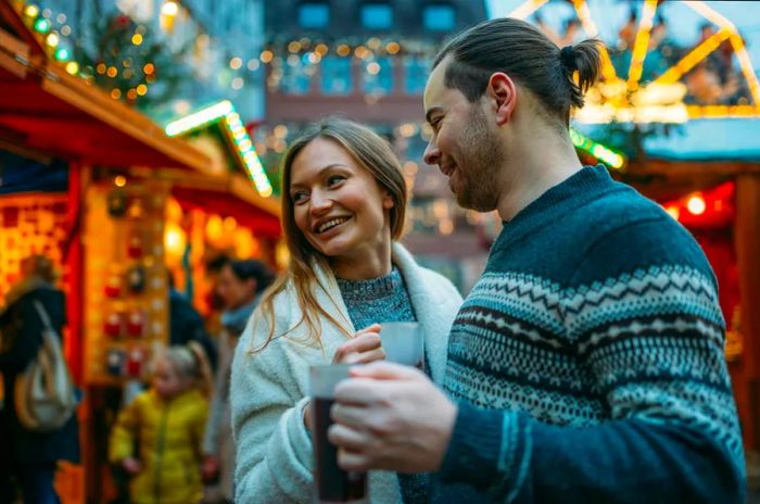 A diverse couple relishes the Christmas spirit at a German market.