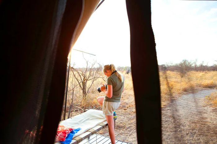 A teenage girl reviews her photos at a camp in Botswana