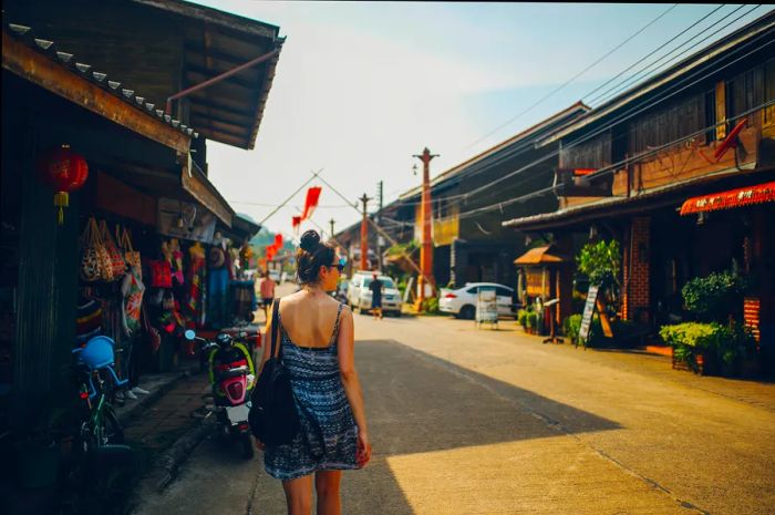 A young woman strolling through the charming Old Town of Koh Lanta, Thailand