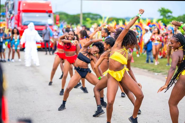 A group of women dance in a vibrant parade for Crop Over.