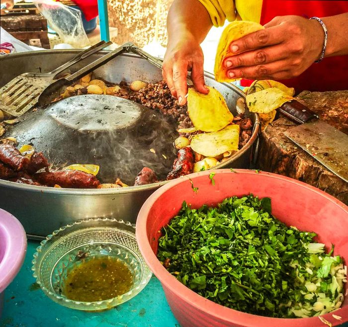 A street vendor's hands preparing food for Day of the Dead festivities in Mexico