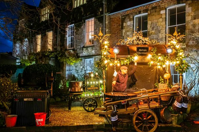 A vendor at his kiosk offers roasted chestnuts at the Christmas market held at Winchester Cathedral.