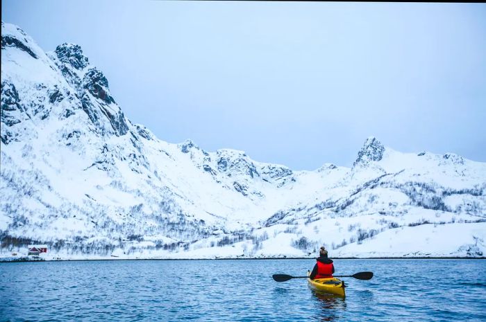 View of a woman kayaking in the Lofoten Islands, Norway